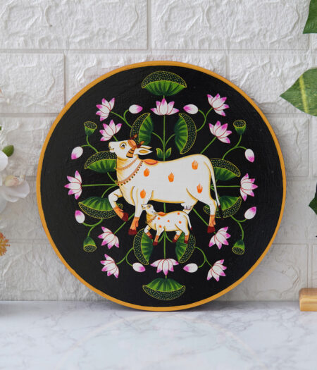Pichwai Painting: This beautiful pichwai painting features a mother cow and her calf nuzzling each other, surrounded by a vibrant array of flowers