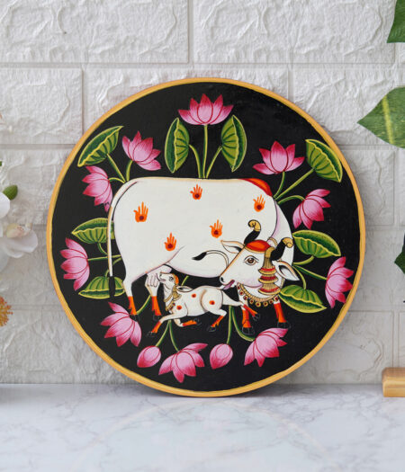 Pichwai Painting: This beautiful pichwai painting features the Hindu deity Krishna cradling his beloved calf, surrounded by a vibrant array of flowers