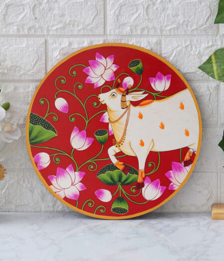 Pichwai Painting: This beautiful pichwai painting features a serene white cow adorned with a vibrant floral headdress